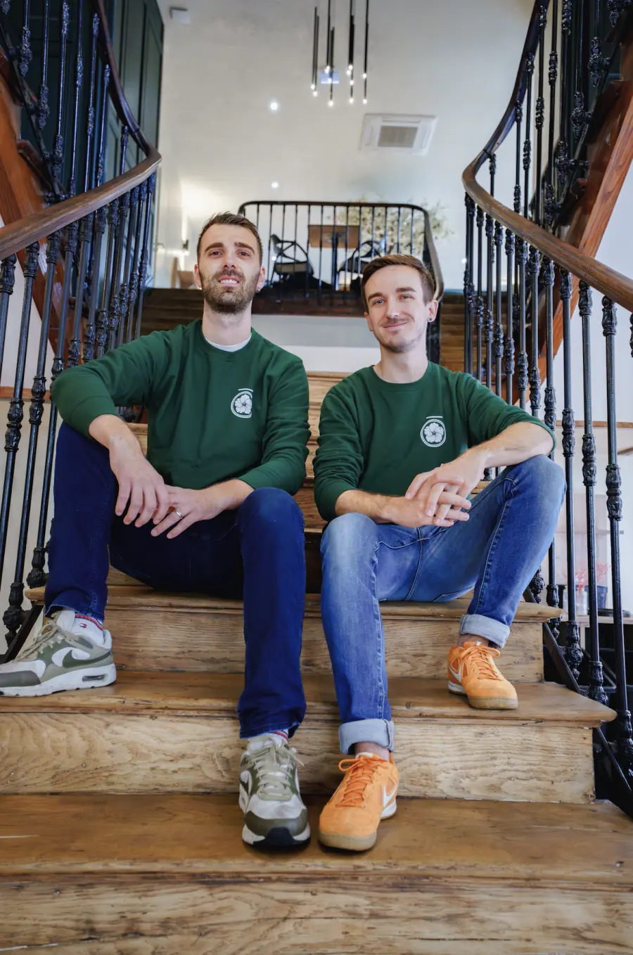 Armand et Julien, fondateurs de BLŌSSOM, assis dans l’escalier du café