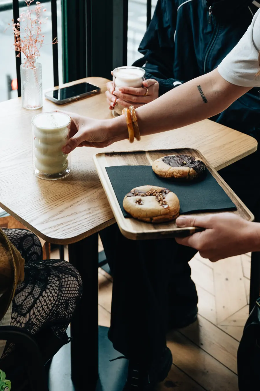 Service en salle chez BLŌSSOM : lattes et cookies sur un plateau